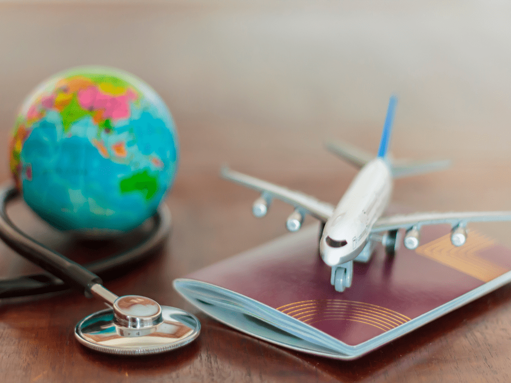 A globe, stethoscope , passport and airplane symbolizing travel insurance