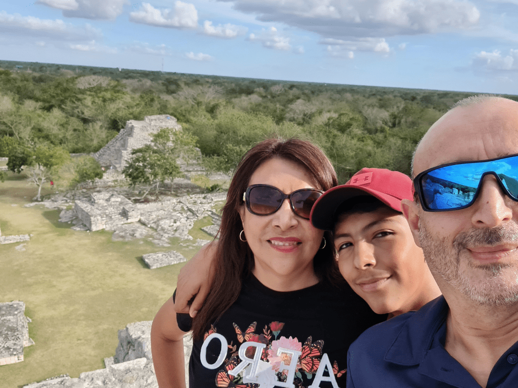 family of 3 on top a pyramid at Ek Balam archeological site in Yucatan Mexico