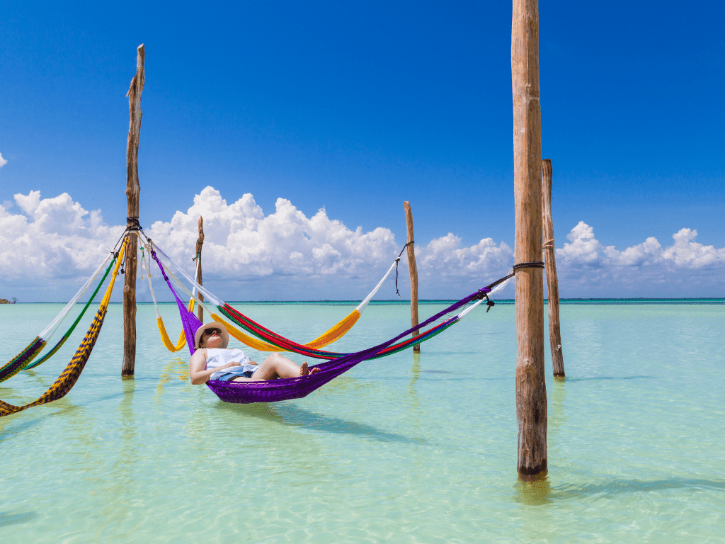 male in a hammock over the ocean in Yucatan