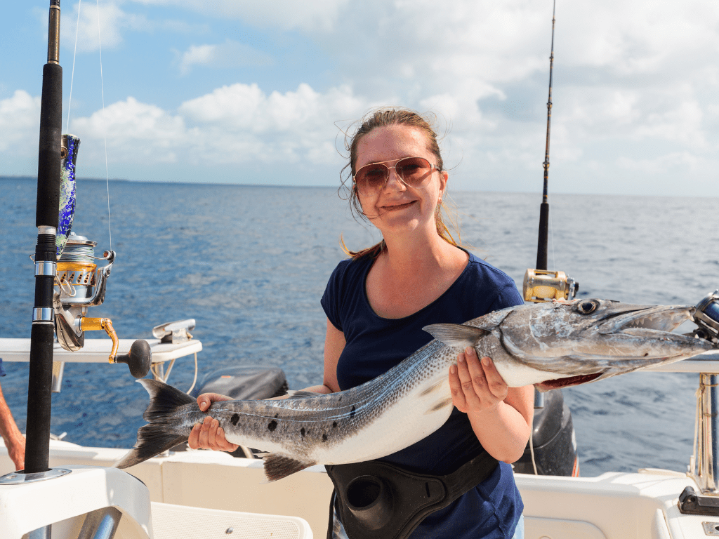 woman holding a fish they caught while deep sea fishing